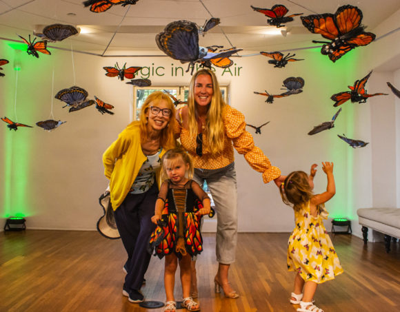 Family standing under a piece of butterfly art