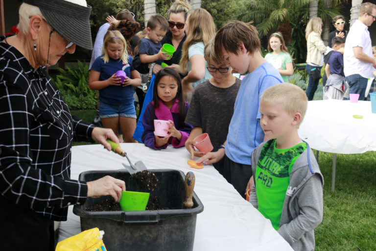 Casa Romantica Volunteer helps children in a gardening activity